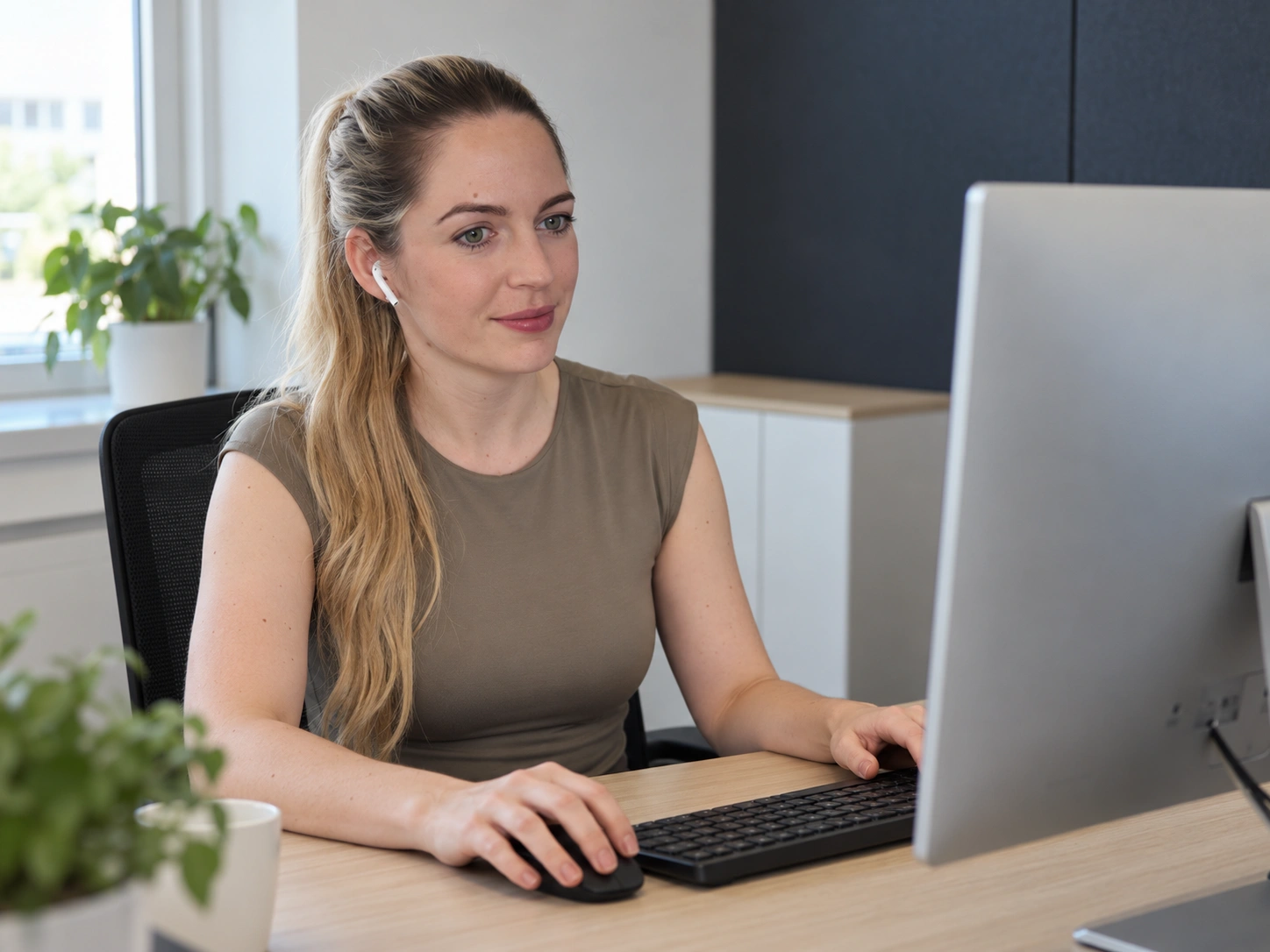 Sanne aan het werk aan de computer met een AirPod